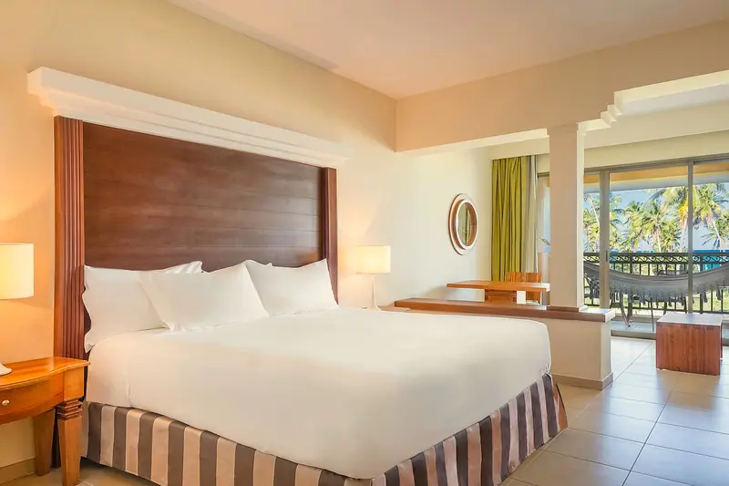 Junior suite com cama king e varanda voltada para o mar
