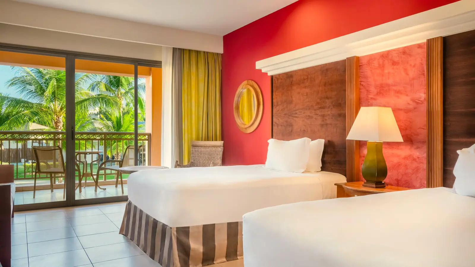 Junior suite com duas camas de casal e porta de vidro para a varanda